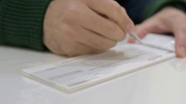 Bankada çek yazan eller.