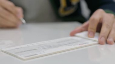 Bankada bir çek imzalıyorum.