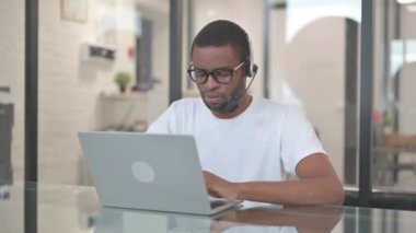 Çağrı Merkezi 'nde kulaklıklı, gülümseyen Afrikalı Amerikalı.