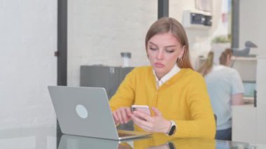 Telefonla ve laptopla çalışan sıradan sarışın kadın.