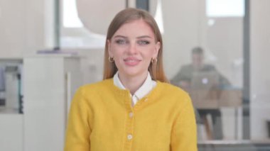 Ofisteki gülümseyen genç kadının portresi.
