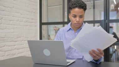 Genç Afrikalı Kadın Belgeler ve Laptop Üzerinde Çalışıyor