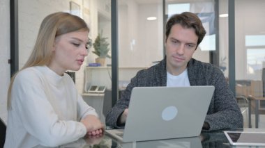 Ofiste bilgisayar üzerinde çalışan ırklar arası çift.