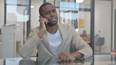 Afrikalı adam telefonda konuşuyor, pazarlık yapıyor.