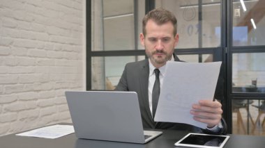 Belgeler ve Dizüstü bilgisayar üzerinde çalışan Orta Çağ İşadamı