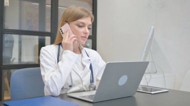 Kadın Doktor İş yerinde Telefonla Konuşuyor