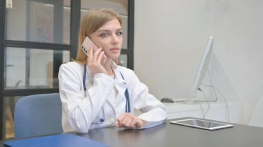 Female Doctor Talking on Phone with Patient