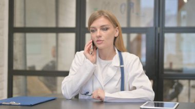 Sarışın Kadın Doktor Hastayla Telefonda Konuşuyor