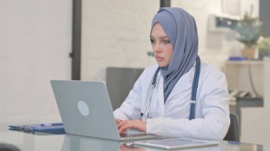 Müslüman Kadın Doktor Laptop 'ta çalışıyor, daktilo ediyor