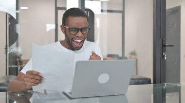 Genç Afrikalı Adam Laptop ve Belgeleri Kullanırken Kutluyor