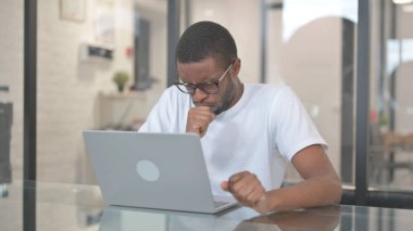 Laptop üzerinde çalışırken Afrikalı Amerikalı Adam öksürüyor