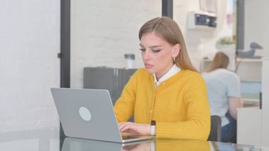 Ofiste dizüstü bilgisayarda çalışan sarışın sıradan bir kadın.