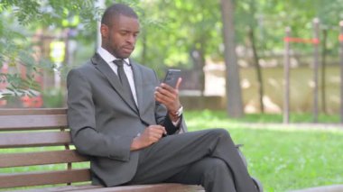 Afrikalı İşadamı Parktaki Açık havada Akıllı Telefon Kullanıyor