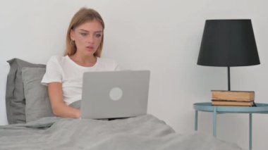 Yatakta Otururken Dizüstü Bilgisayarda Çalışmayı Kutlayan Genç Kadın