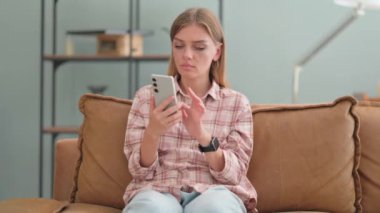 Evdeki Kanepede otururken Çevrimiçi Kaybı Eleştiren Genç Kadın