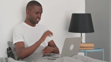 Afrikalı Adam Yatakta Otururken Dizüstü Bilgisayarda Çalışmayı Kutluyor