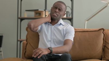 Evdeki Kanepede oturan boynu ağrıyan Afrikalı adam