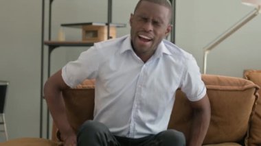 Evdeki Koltukta oturan Sırt Ağrısı Olan Afrikalı Adam