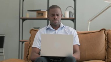 Evde dizüstü bilgisayar kullanan Öksüren Hasta Afrikalı Adam