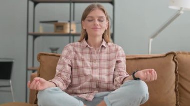 Evde yoga yapan genç bir kadın.