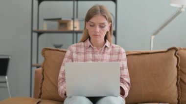 Dışarıda Bench 'te otururken laptopta çalışan genç bir kadın.