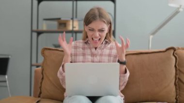 dizüstü bilgisayarda çalışan kızgın genç kadın