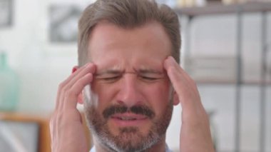 Baş ağrısı olan genç adama yaklaş.