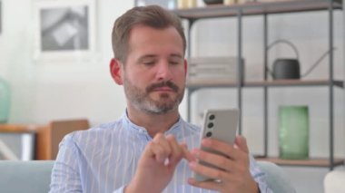 Orta yaşlı adamın portresi İnternet 'te Ev Telefonunda geziniyor