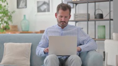 Orta yaşlı adam laptopta kaybından şok oldu.