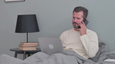 Yatakta Telefonda Konuşan Orta Yaşlı Adam