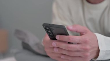 Male Hand Kullanma Telefonunu, Yatakta Mide Üzerine Uzanırken Kapat