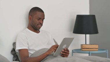 Afrikalı Adam Yatakta Otururken Dijital Tablet Kullanıyor