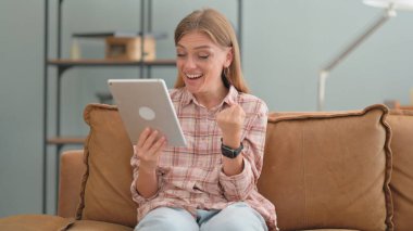 Tabletteki Başarıyı Kutlayan Genç Kadın Evdeki Koltukta Otururken