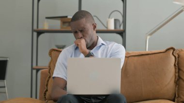 Evde dizüstü bilgisayar kullanan Öksüren Hasta Afrikalı Adam