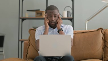 Evde Dizüstü bilgisayar kullanan Baş Ağrısı Olan Afrikalı Adam