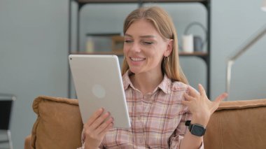Tablet 'te Video Sohbeti Yapan Genç Kadın Evdeki Koltukta Otururken