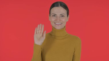 Casual Young Woman Waving Hand to Welcome on Red Background, Portrait clipart