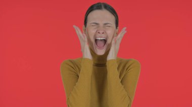 Hayal kırıklığına uğramış genç bir kadın Kızıl Arkaplanda yüksek sesle bağırıyor, Portre