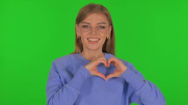 Yeşil Arkaplanda Elleri Olan Kalp İşareti Yapan Kadın