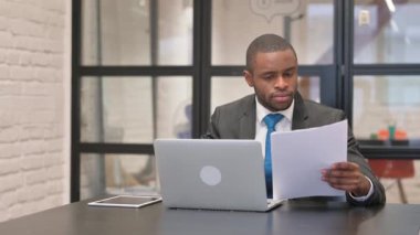 Belgeler ve Bilgisayarlar Üzerinde Çalışırken Afrikalı İşadamı Kutluyor