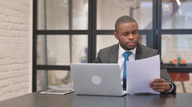 Afrika işadamı belgeleri ve Laptop üzerinde çalışma