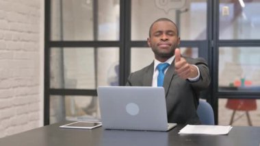 Dizüstü bilgisayar kullanan Afrikalı İşadamı Başparmağını kaldırdı