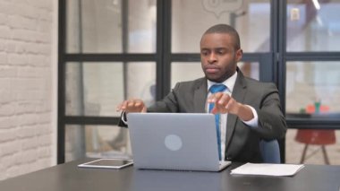 Afrikalı İşadamı Dizüstü bilgisayarla çalıştıktan sonra ofisten ayrılıyor