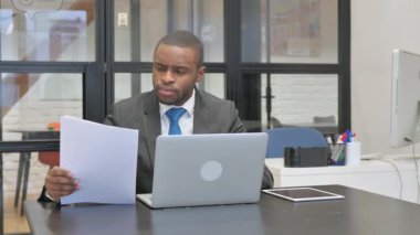 Belgeler ve Laptop üzerinde çalışan Afrikalı Amerikalı İşadamı