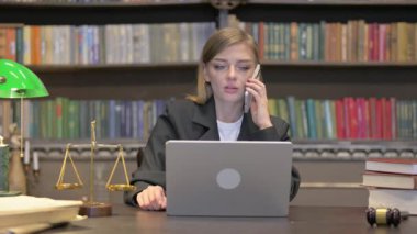 Bayan Avukat Laptop 'la telefonda konuşuyor.