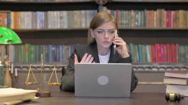 Laptop kullanırken telefonda konuşan kızgın kadın avukat.