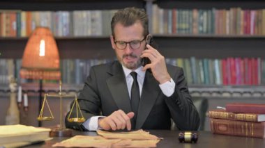 Öfkeli Orta Çağ Avukatı Ofisteyken Telefonda konuşuyor