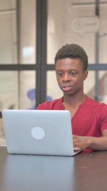 Genç Afrikalı Adam 'ın Laptop' ta Başarı Kutlamasının dikey videosu