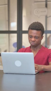 Laptop 'ta çalışırken Sinirli Genç Afrikalı Adam' ın dikey videosu