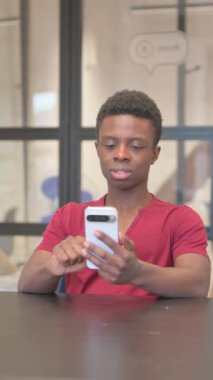 Ofiste Telefonu Kullanan Tatminsiz Genç Afrikalı Adam 'ın dikey videosu
